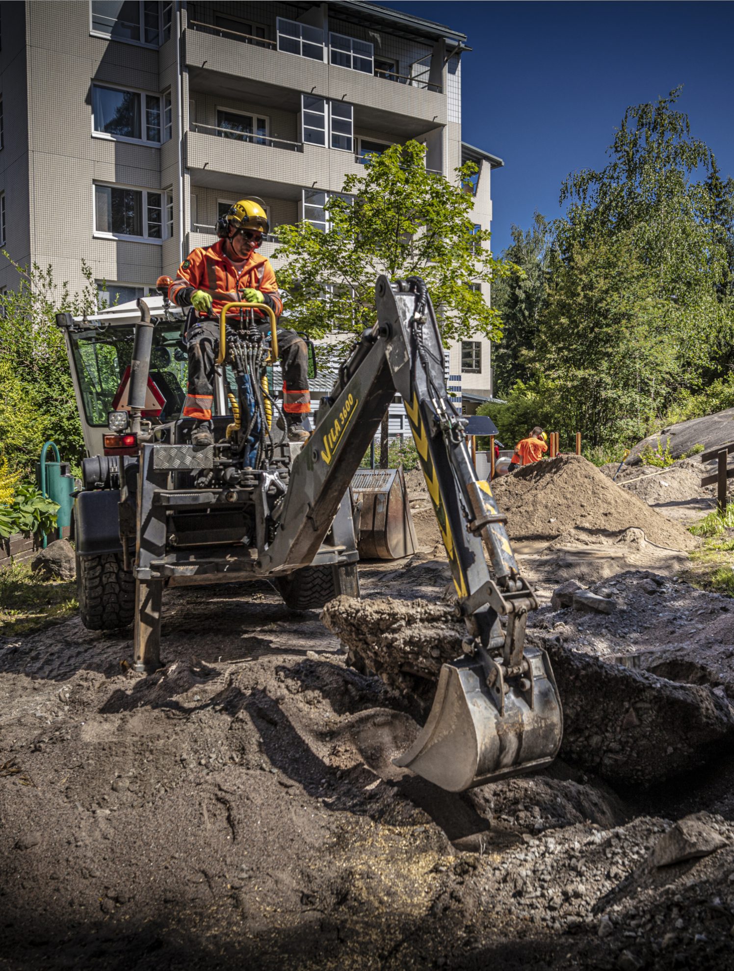 En anleggsarbeider i minigraver utfører gravearbeider i forberedelse av et oppgraderingsprosjekt på en av våre kunders grøntarealer